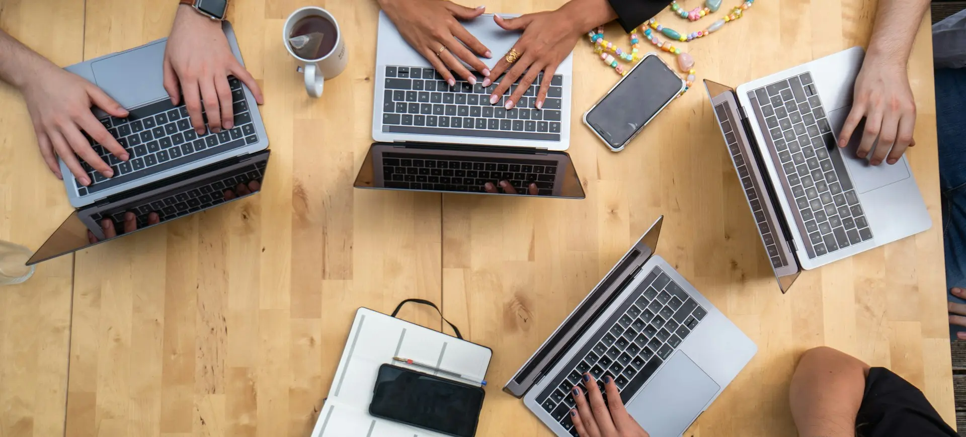 person using macbook pro on brown wooden table